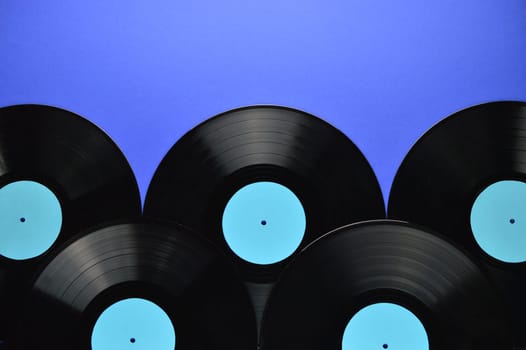 border of old black vinyl records with blank cyan labels on blue background