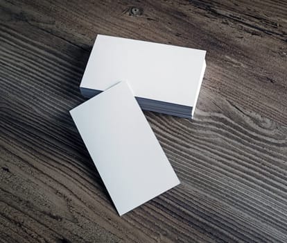 Photo of blank white business cards on wooden background. For design portfolios. Blank template for branding identity.