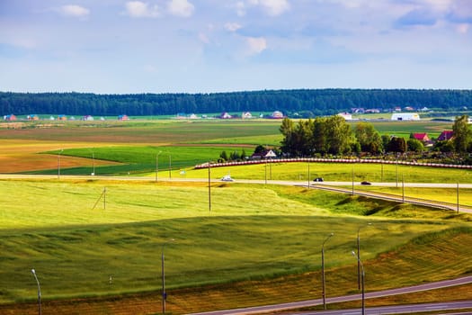 Meadows, fields, village and road in the countryside. Minsk region, Belarus