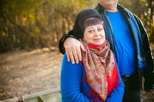 adult couple walking in autumn park. husband and wife walking outdoors in autumn last days