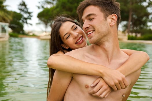 Portrait of a young couple embraced inside the pool