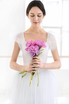 Portrait of a young bride with flowers on white studio