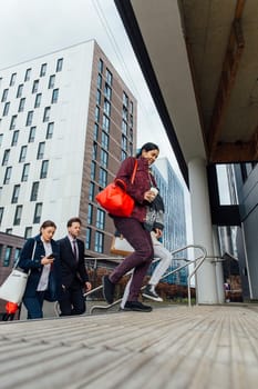 Group of people are walking up the entrance to their corporate office building in the city.