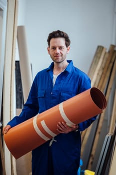 Portrait of a male construction worker with a roll of flooring in his hands.