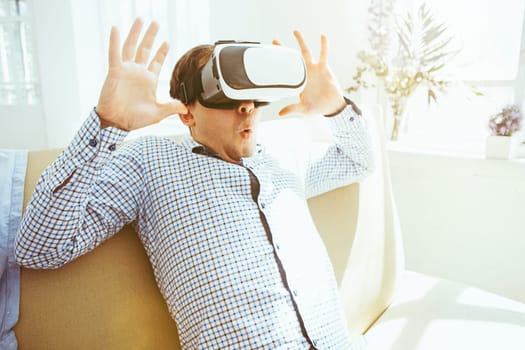 The man with glasses of virtual reality at home. Future technology concept.