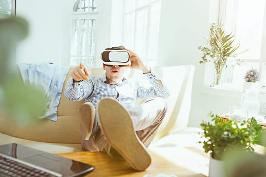 The man with glasses of virtual reality at home. Future technology concept.