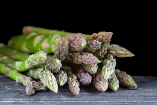 Wild green asparagus isolated on a black background