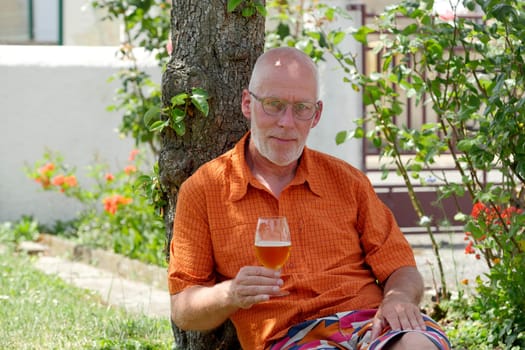 a mature man drinking a beer outside