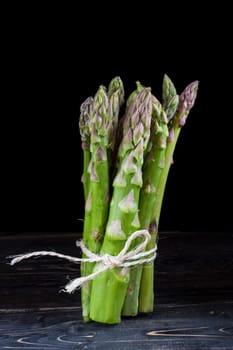 Bunch of wild green asparagus on a black background