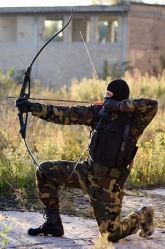 The soldier is shooting with bow and arrow.
