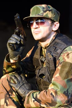 The soldier in uniform is holding the gun.