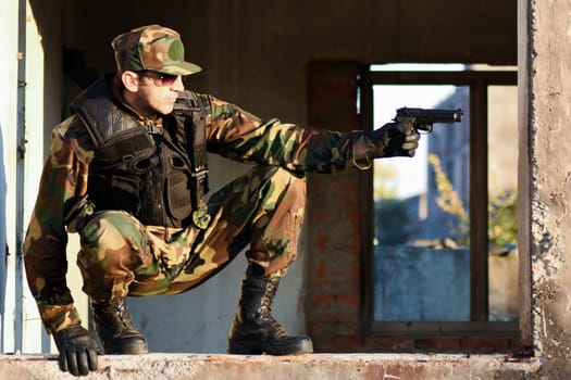 The soldier is holding a handgun, profile view.