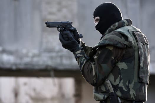The soldier is shooting with the gun.