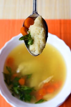 Homemade soup with noodles, carrot and parsley.