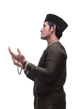 Young asian muslim man praying with prayer beads isolated over white background