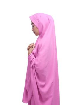 Side view of asian muslim woman with veil praying isolated over white background