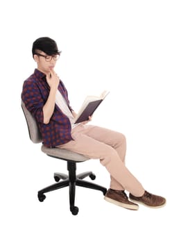 A young Asian man sitting in a checkered shirt and glasses, reading.in a book, isolated for white background..