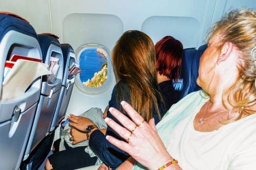 Interior of a modern aircraft and passengers during the cargo approach at the airport of a holiday island in the south.