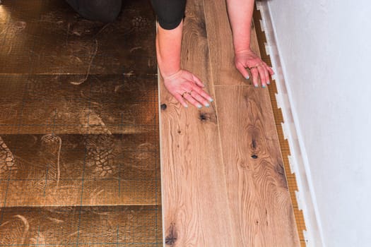 Woman in the installation of laminate made of plastic or vinyl...