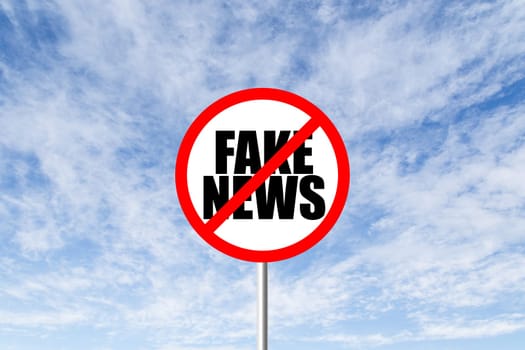 Stop fake news prohibitory traffic sign against blue cloudy sky
