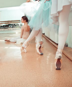 Thr seven ballerinas at ballet rack in the rehearsal hall of the theater