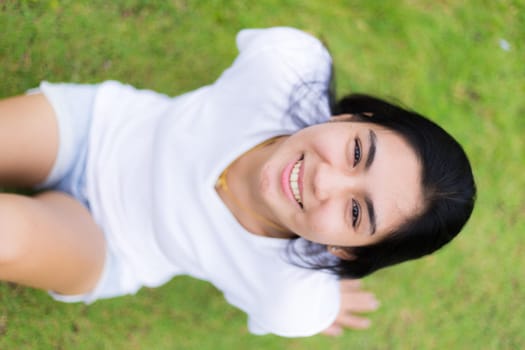Asian woman is sitting on the rock in the park