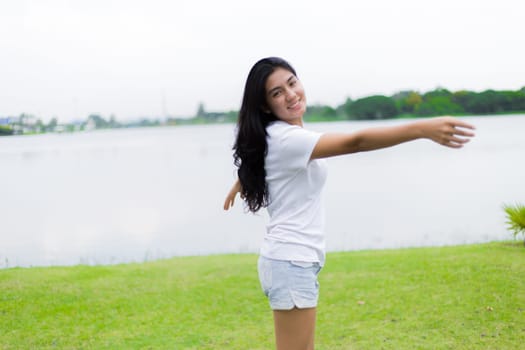 Asian woman is sitting on the rock in the park