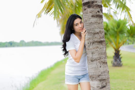 Asian woman is sitting on the rock in the park
