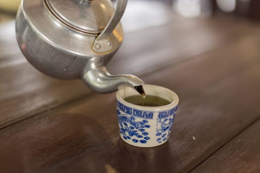 Teapot pouring tea into a cup
