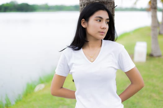 Asian woman is sitting on the rock in the park