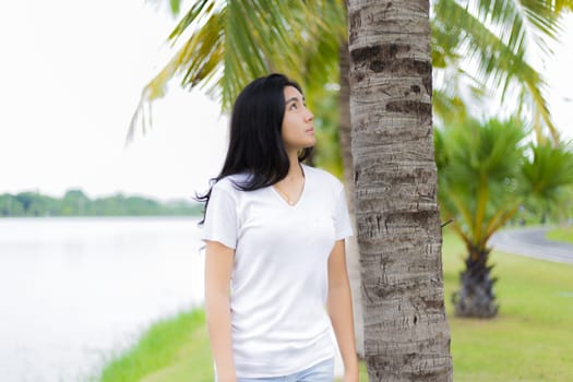Asian woman is sitting on the rock in the park