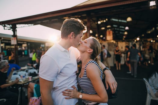 Happy couple kissing in Queen Victoria Market, Australia.