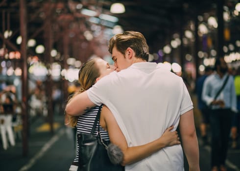 Happy couple kissing in Queen Victoria Market, Australia.