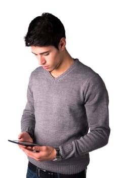 Handsome young man holding ebook reader and reading text on it, standing isolated on white background
