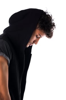 Profile of handsome tough young man in dark hoodie isolated on white background, looking down