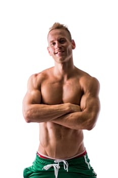 Fit shirtless male model smiling, posing with a lot of confidence, arms crossed on his chest, isolated on white