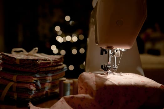 Low key detail of automatic sewing machine, shot from the side