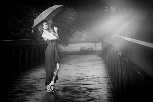 Young attractive woman with red umbrella after rain in nature