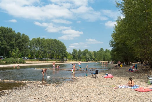ROUFFILLAC, FRANCE - AUGIST 17, 2016: Unknown tourists enjoying the cooling water of the Dordogne river during a hot summer day