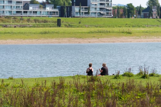 DEVENTER, NETHERLANDS - AUGUST 27, 2016: two unknown women sitting at a river