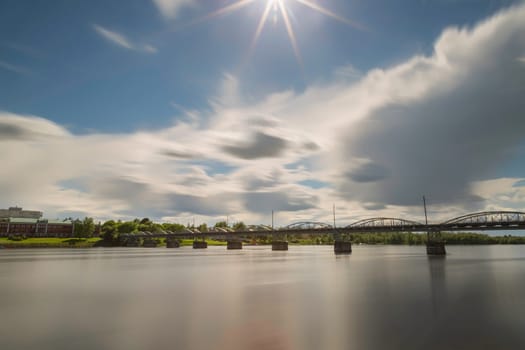 Bride over River in Umea, Sweden with a partly cloudy sky.