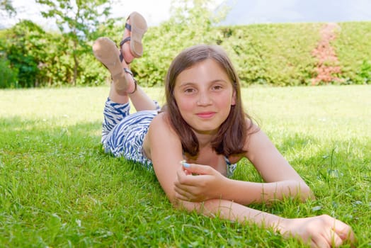a beautiful pre teenage girl laying in grass