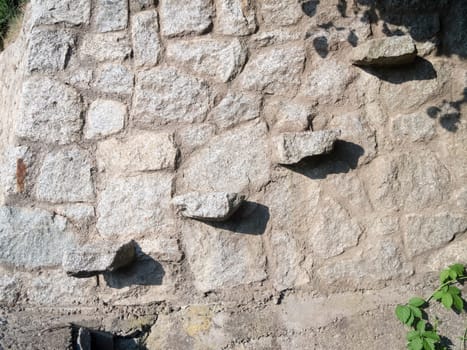 Steps protruding from a fieldstone wall.