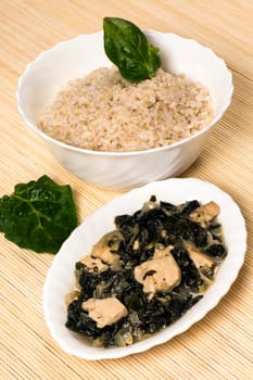 Chicken with mangold and spinach and a bowl of rice is Asian food.