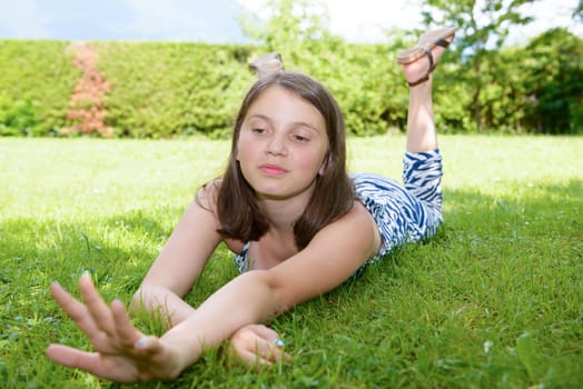 a beautiful pre teenage girl laying in grass