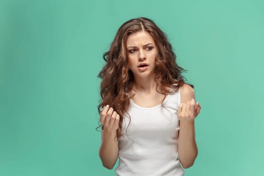 Portrait of an angry woman looking away on a blue background