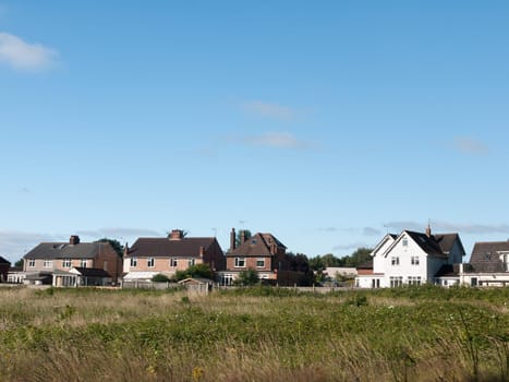 back of houses in a field in summer light wivenhoe essex england uk