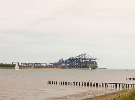 blue sea structure cranes at cargo dock loading in distance felixstowe essex