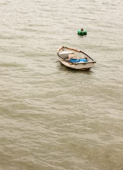 a single wooden boat no people in a grey sea alone