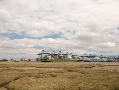 blue sea structure cranes at cargo dock loading in distance felixstowe essex